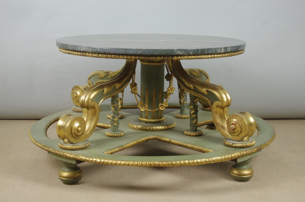 A low circular French Neoclassical style centre table featuring a dark green marble top and a sage green painted base with carved parcel-gilt scroll supports. View XV