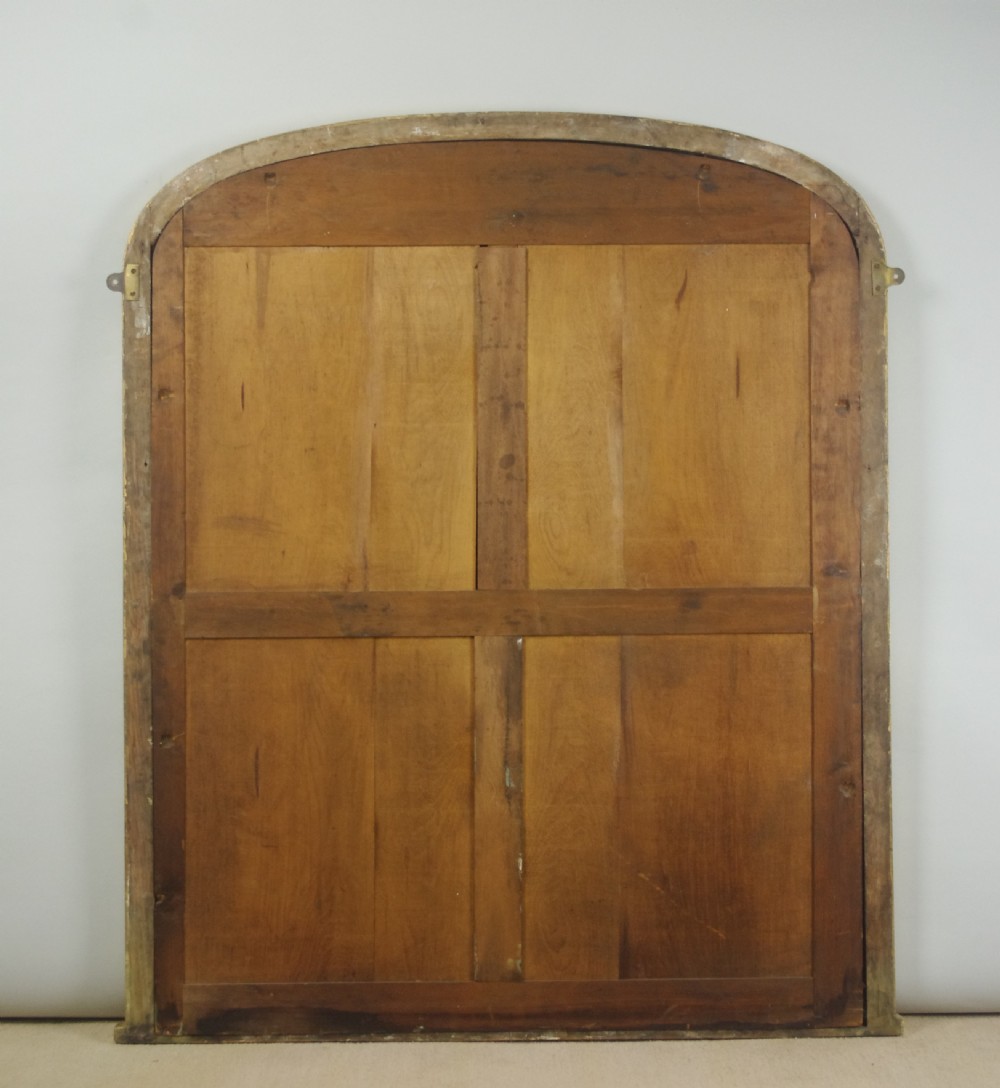A Victorian arched overmantel mirror featuring a gilded frame with ornate decorative moulding and a flat base. View IX