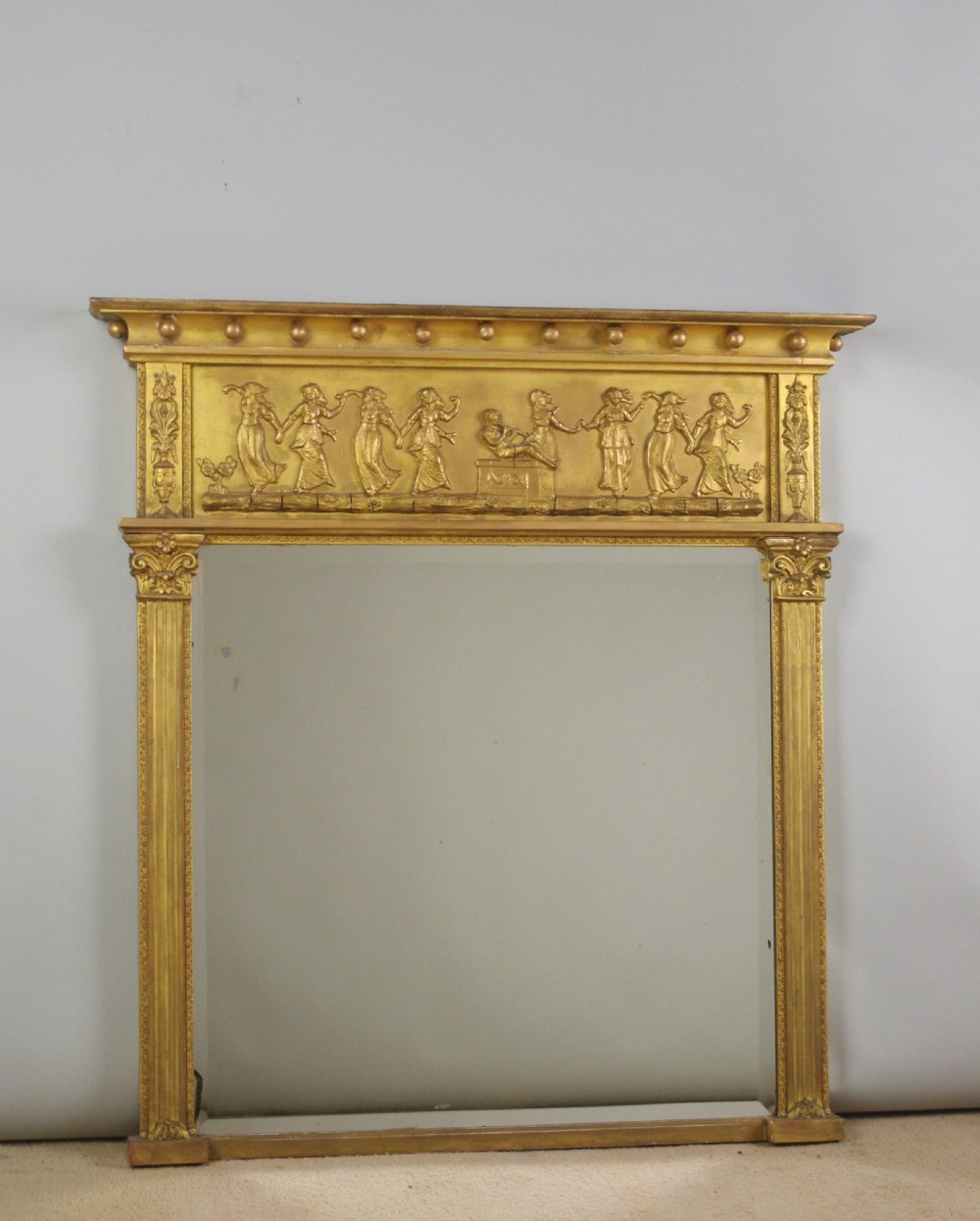 A rectangular Victorian giltwood overmantel mirror with a classical figure frieze and fluted side columns.