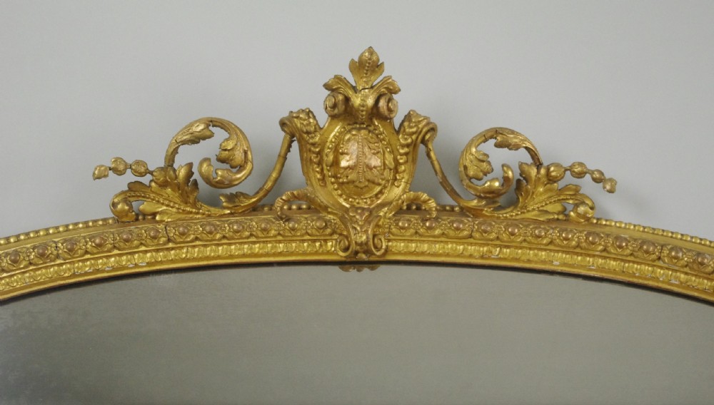 A large Victorian overmantel mirror featuring an arched gold leaf frame with cresting and beaded details. View III