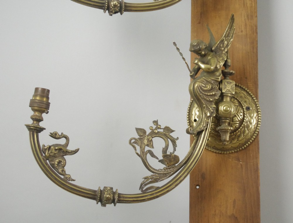 A pair of cast brass Victorian wall sconces featuring sculpted cherubs, mythological creature accents, and ornamental scroll arms. View III