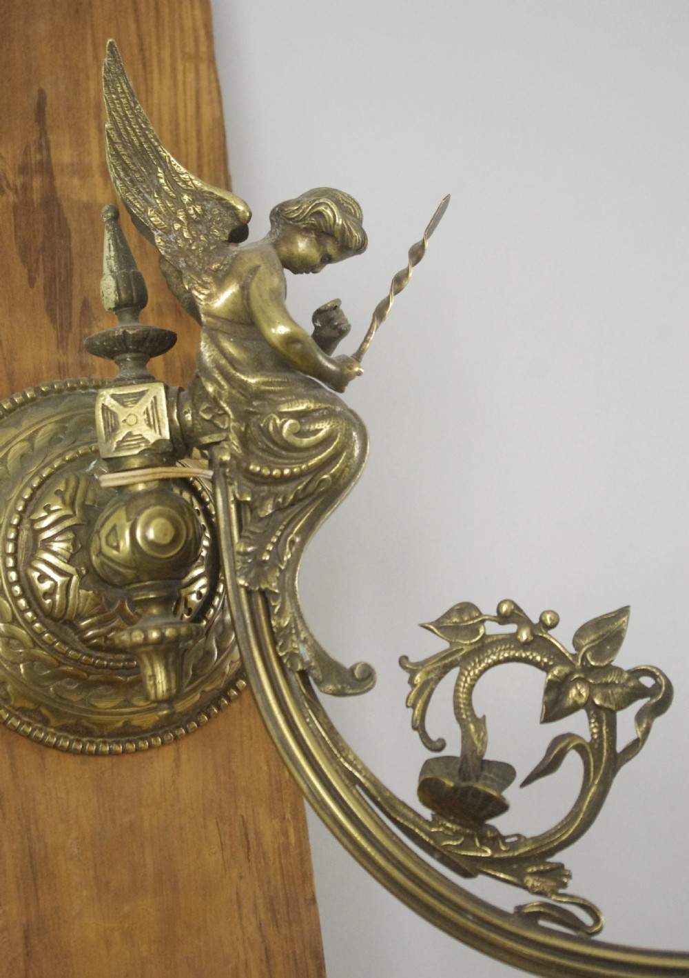 A pair of cast brass Victorian wall sconces featuring sculpted cherubs, mythological creature accents, and ornamental scroll arms. View V