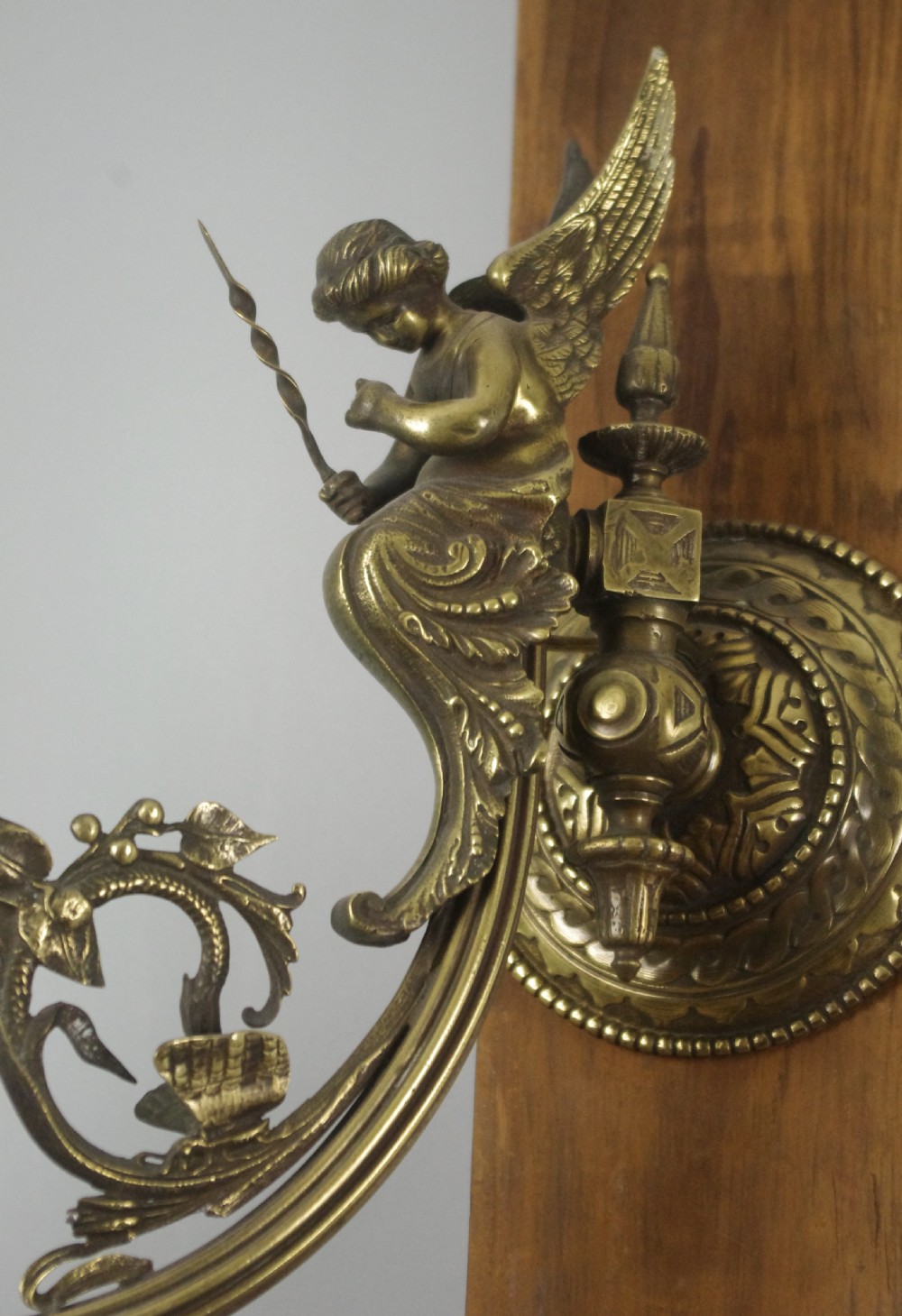 A pair of cast brass Victorian wall sconces featuring sculpted cherubs, mythological creature accents, and ornamental scroll arms. View VI