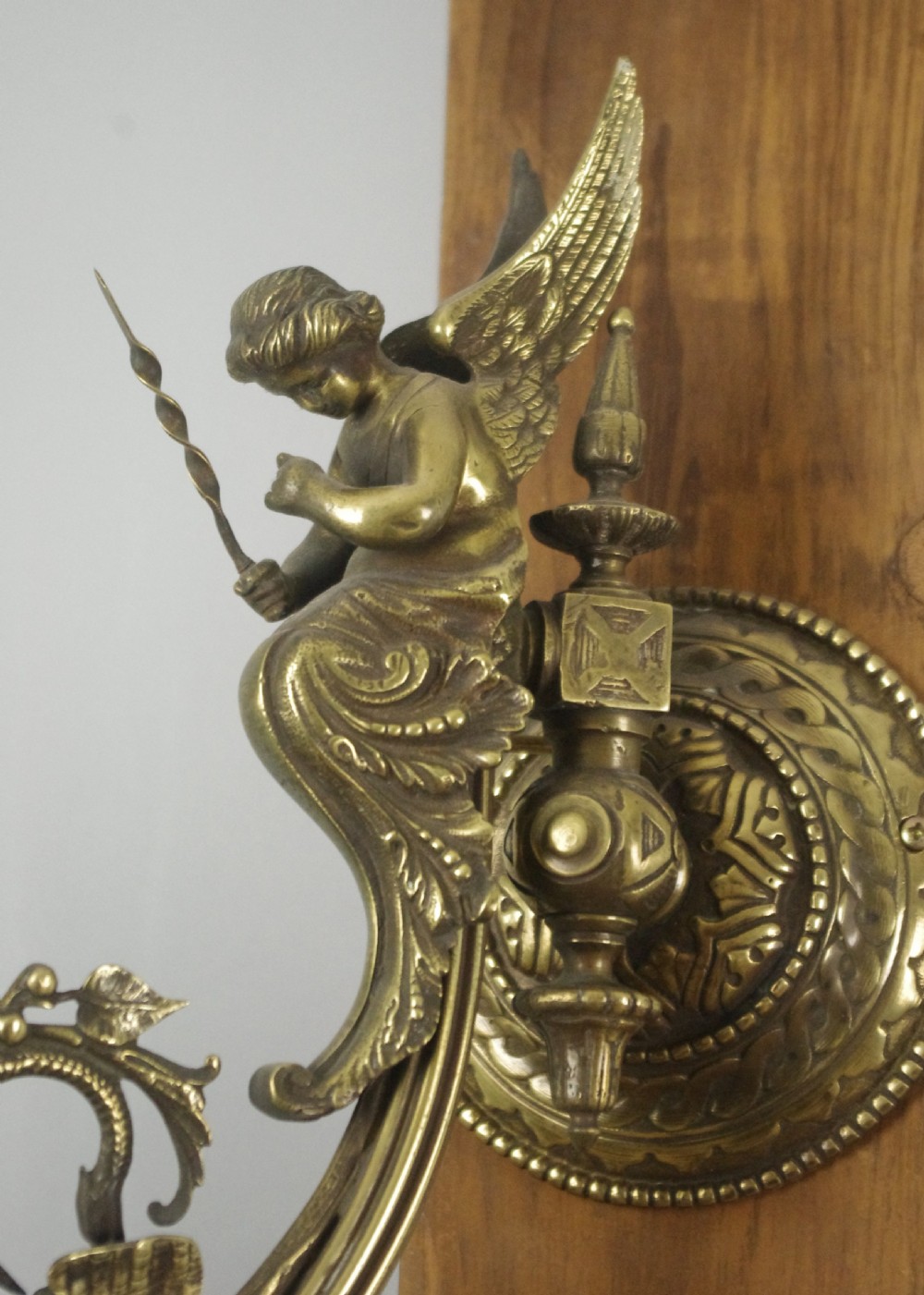 A pair of cast brass Victorian wall sconces featuring sculpted cherubs, mythological creature accents, and ornamental scroll arms. View VII