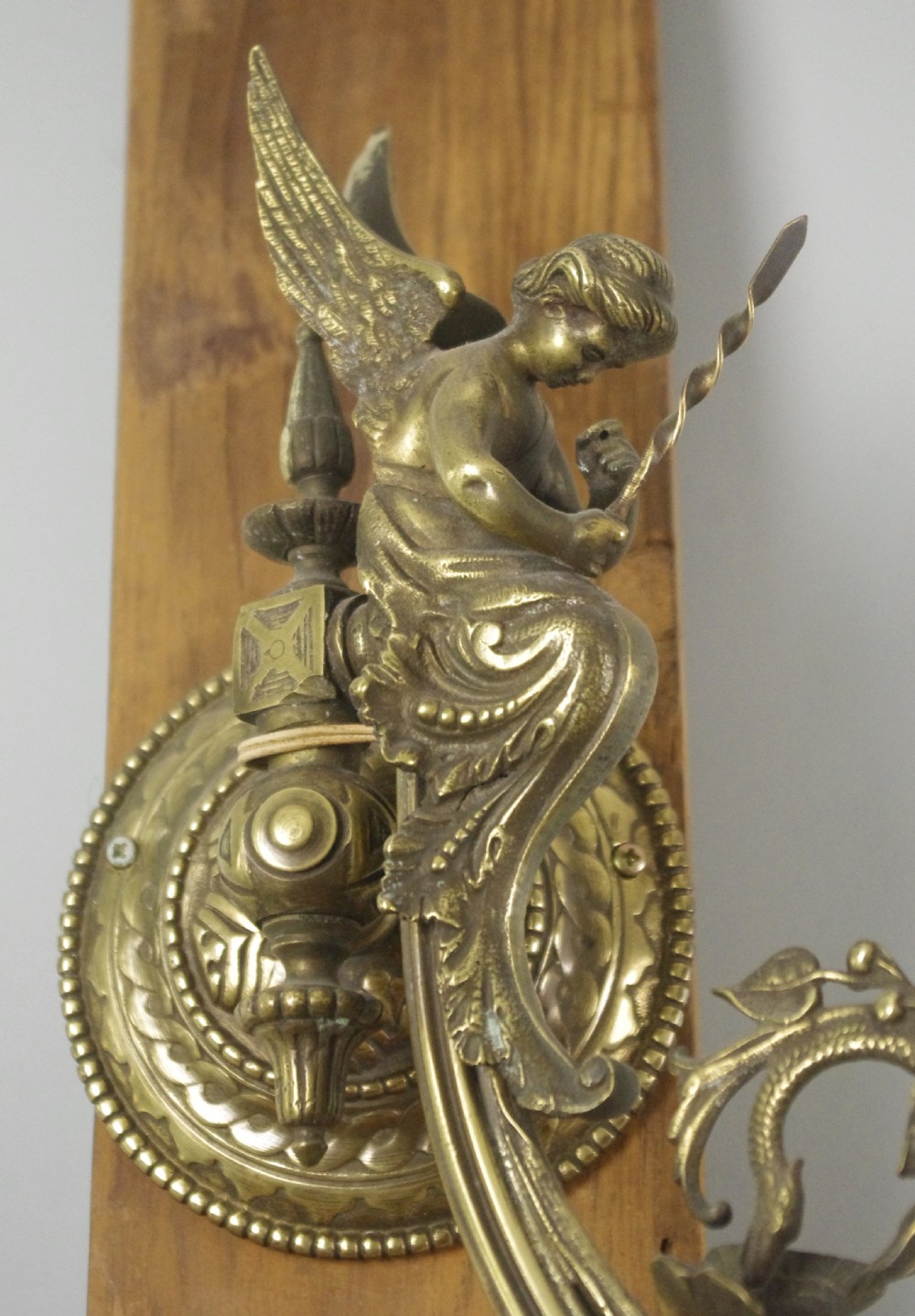 A pair of cast brass Victorian wall sconces featuring sculpted cherubs, mythological creature accents, and ornamental scroll arms. View VIII