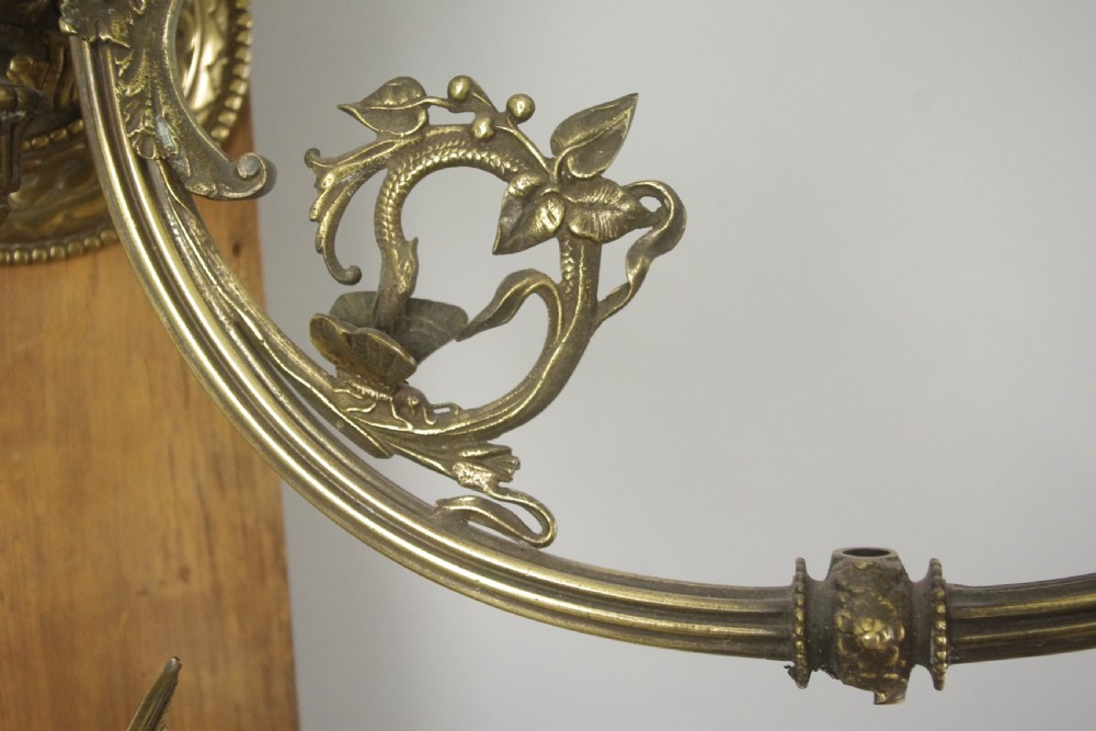 A pair of cast brass Victorian wall sconces featuring sculpted cherubs, mythological creature accents, and ornamental scroll arms. View XII