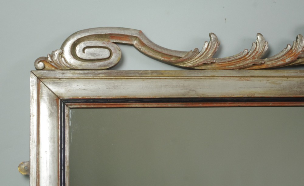 A large Victorian silvered overmantel mirror featuring a carved central urn cresting, foliate top border, and scrolled bottom corners. View VII
