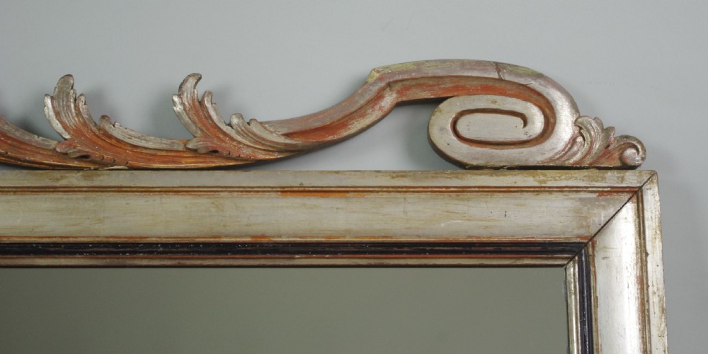 A large Victorian silvered overmantel mirror featuring a carved central urn cresting, foliate top border, and scrolled bottom corners. View VIII