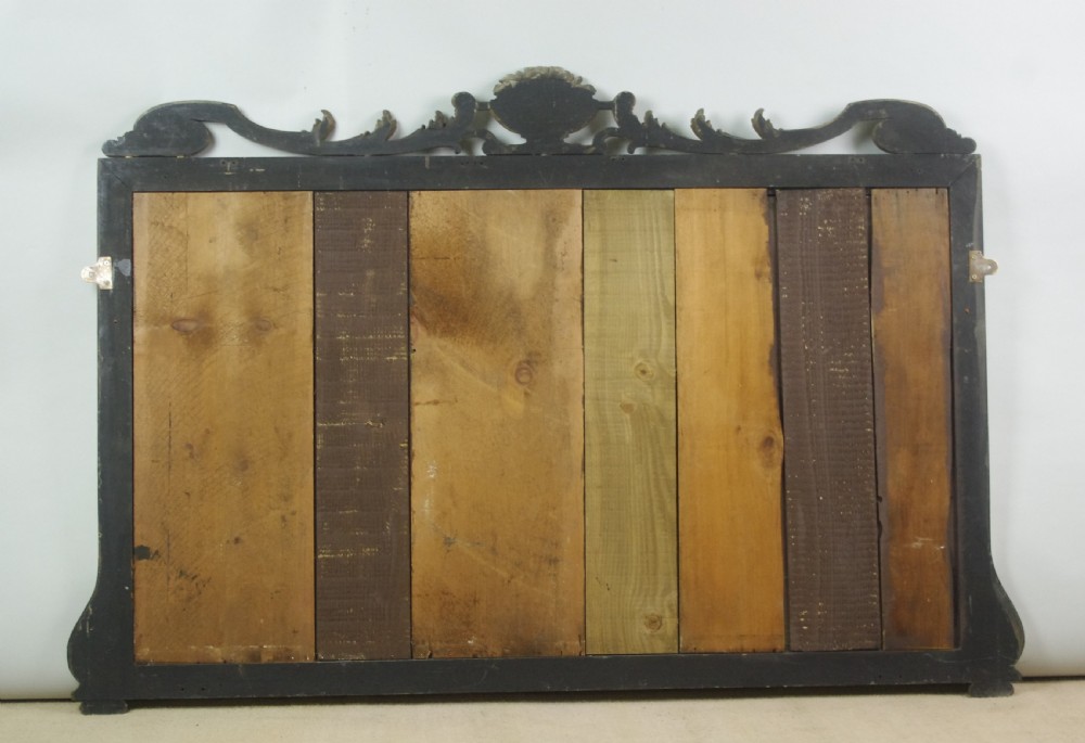 A large Victorian silvered overmantel mirror featuring a carved central urn cresting, foliate top border, and scrolled bottom corners. View XI