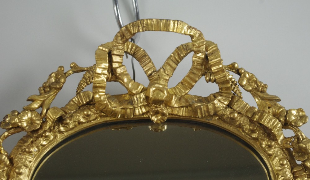 A matching pair of Victorian giltwood wall shelves featuring mirrored backs, ornate bow cresting, and open tiers for displaying small objects. View VIII