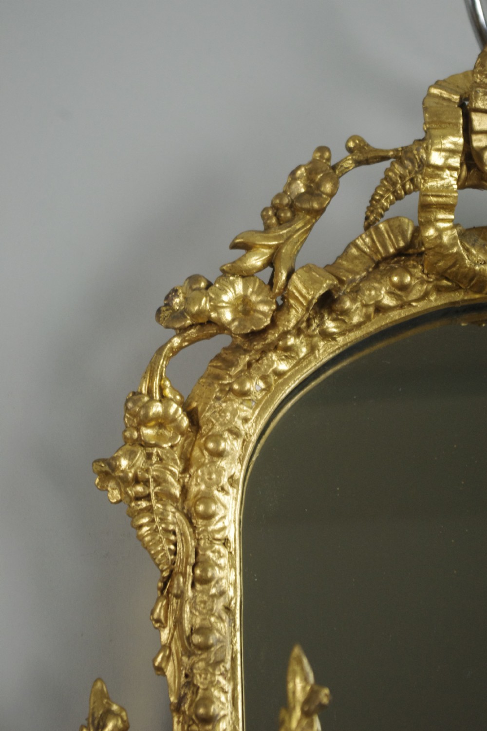 A matching pair of Victorian giltwood wall shelves featuring mirrored backs, ornate bow cresting, and open tiers for displaying small objects. View IX