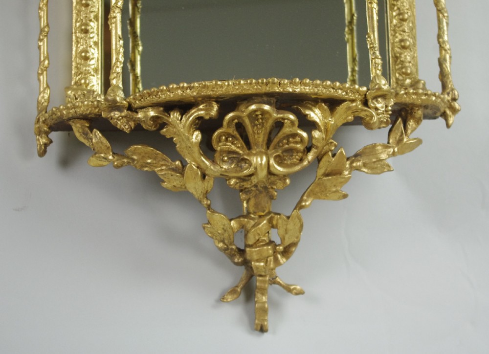 A matching pair of Victorian giltwood wall shelves featuring mirrored backs, ornate bow cresting, and open tiers for displaying small objects. View XII