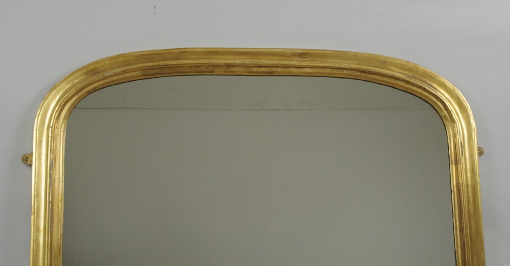 A large Victorian giltwood overmantel mirror with a curved arched top and moulded frame. View II