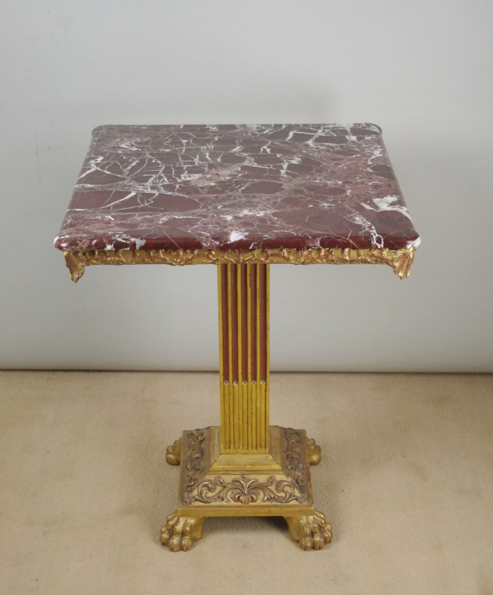 A square Victorian occasional table featuring a red veined marble top resting on a giltwood fluted pedestal with lion paw feet. View III