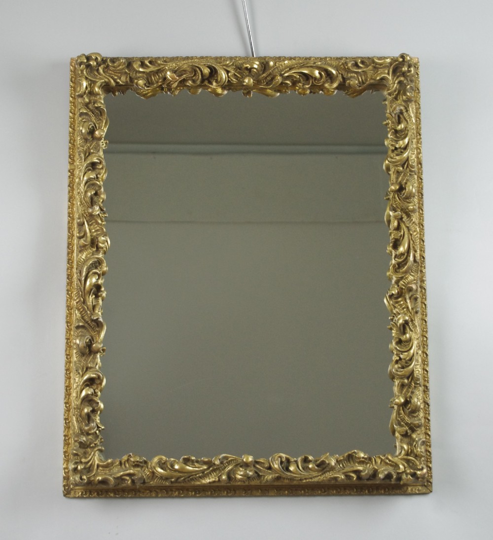 A rectangular Victorian wall mirror featuring an ornate gold giltwood frame with detailed scrollwork moulding.