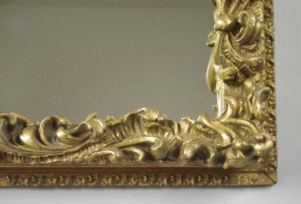 A rectangular Victorian wall mirror featuring an ornate gold giltwood frame with detailed scrollwork moulding. View X