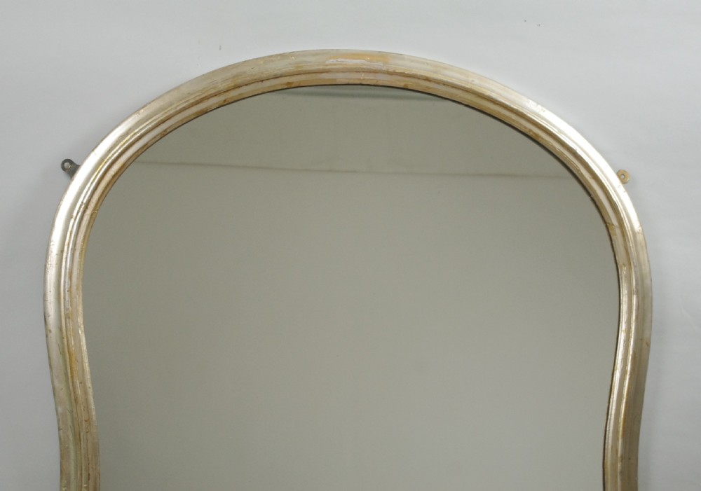 A Victorian silvered overmantel mirror featuring an arched upper frame, molded detailing, and decorative scroll motifs at the base. View II