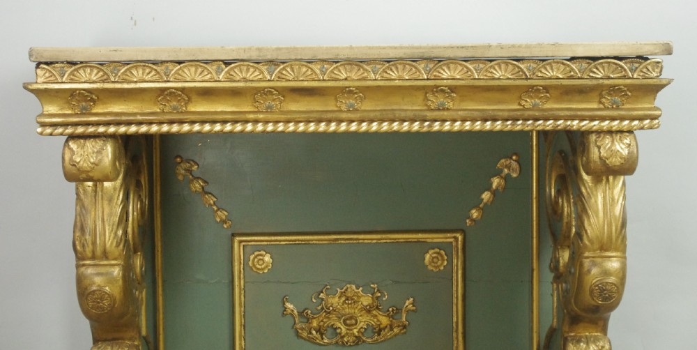 A 19th-century French console table with a cream marble top, green painted base, gilding, and large scroll legs. View VI