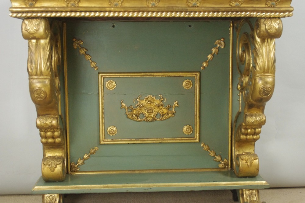 A 19th-century French console table with a cream marble top, green painted base, gilding, and large scroll legs. View VIII