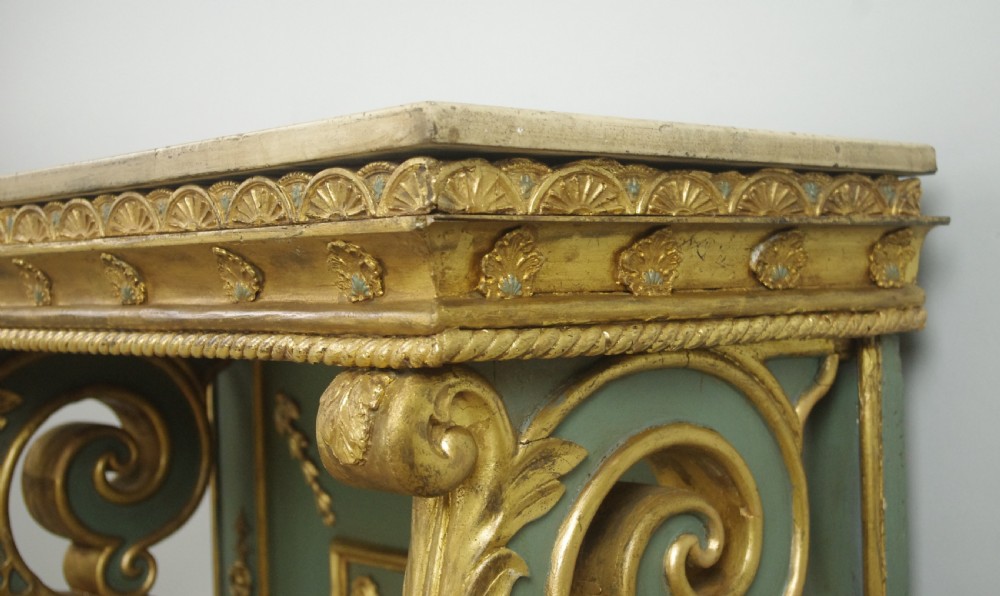 A 19th-century French console table with a cream marble top, green painted base, gilding, and large scroll legs. View XV