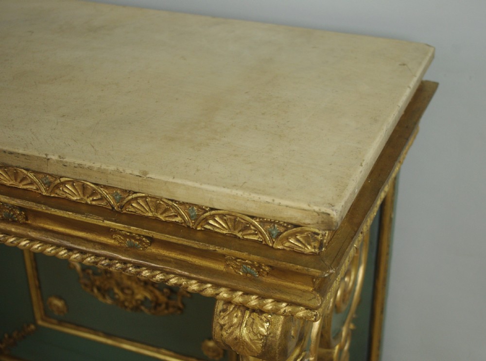 A 19th-century French console table with a cream marble top, green painted base, gilding, and large scroll legs. View XVI