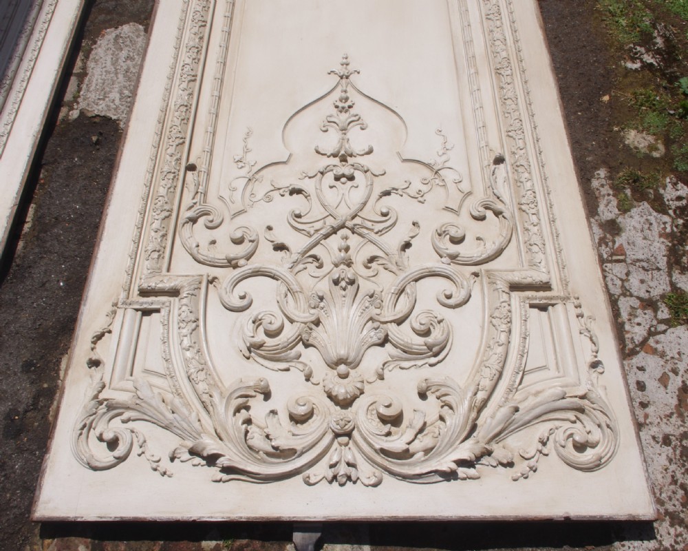 A pair of tall 19th-century French painted wood boiserie wall panels featuring intricate Rococo carved mouldings and foliage motifs in an off-white finish. View XII