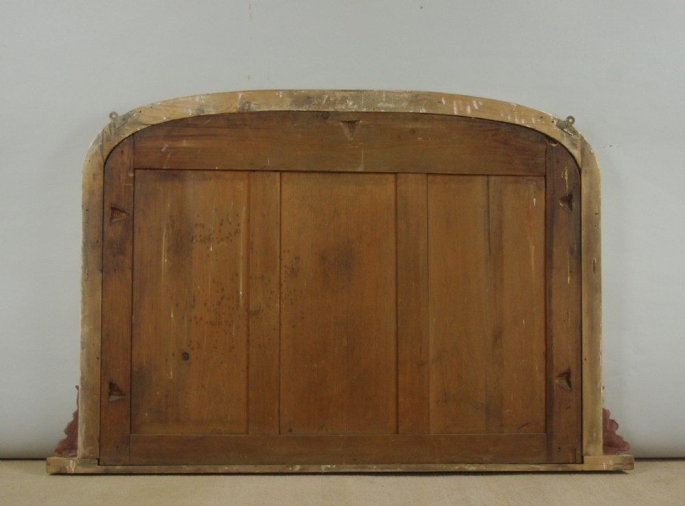 A large Victorian gilded overmantel mirror featuring a low arched frame and ornate acanthus scroll brackets at the base. View VII
