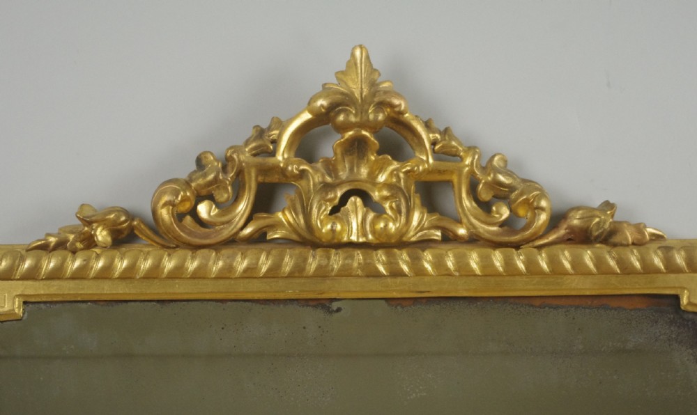 A large Victorian giltwood overmantel mirror featuring rope-twist moulding, a carved top cresting, and scroll corner feet. View III