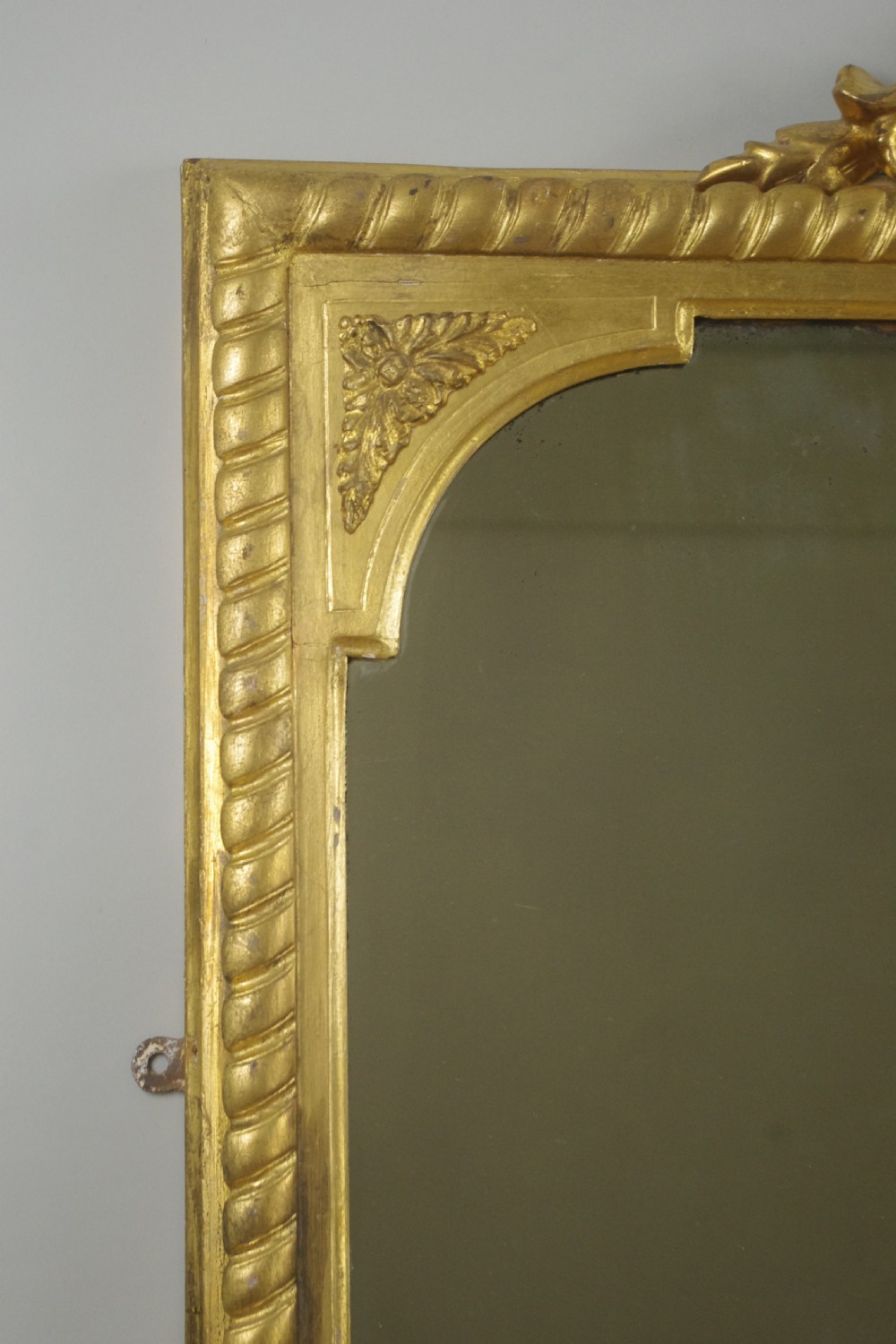 A large Victorian giltwood overmantel mirror featuring rope-twist moulding, a carved top cresting, and scroll corner feet. View IV