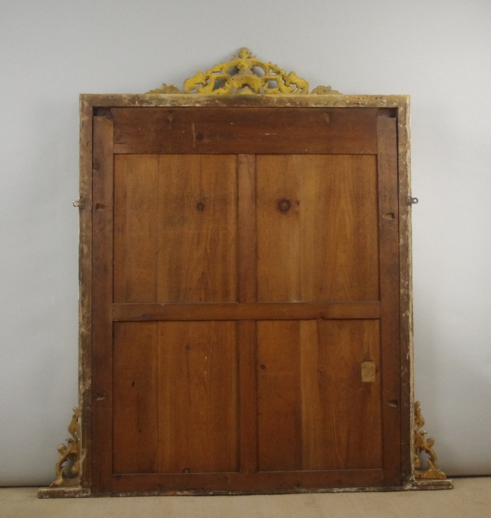 A large Victorian giltwood overmantel mirror featuring rope-twist moulding, a carved top cresting, and scroll corner feet. View IX