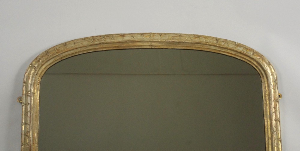 A tall Victorian arched top overmantel mirror featuring a painted wooden frame with geometric carved mouldings and flat base supports. View II