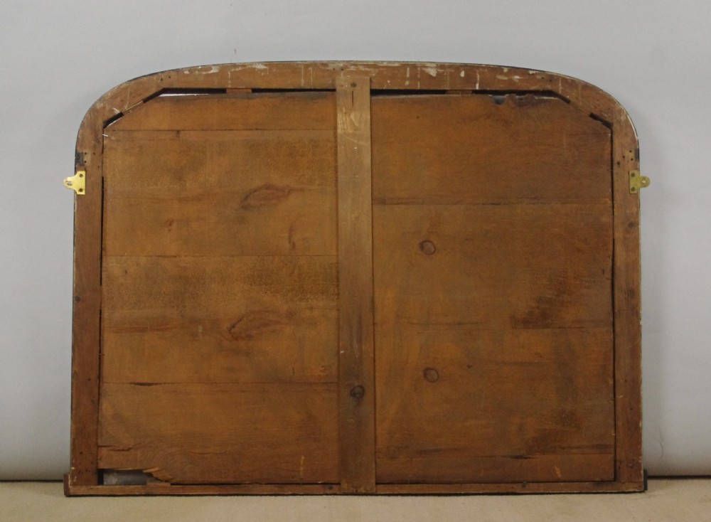 A large Victorian arch top overmantel mirror featuring an ebonised black wood frame with parcel-gilt gold inner moulding. View IX