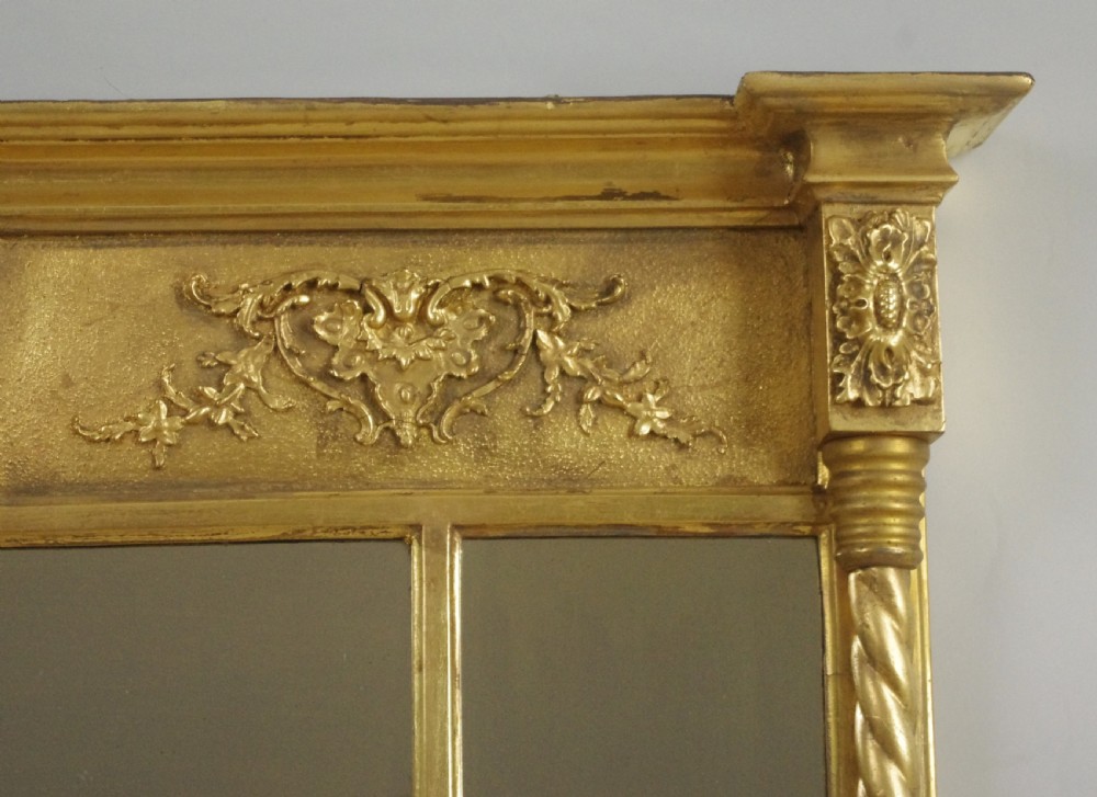 A horizontal Victorian giltwood overmantel mirror with three mirror glass panels, decorative floral relief friezes, and rope-twist side columns. View VI