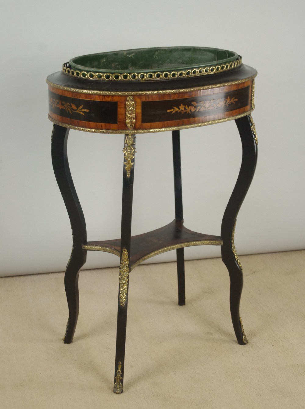 A 19th-century French oval ebonised jardiniere table featuring floral marquetry frieze, gilt-bronze mounts, cabriole legs, and a green metal liner with a pierced brass gallery. View II