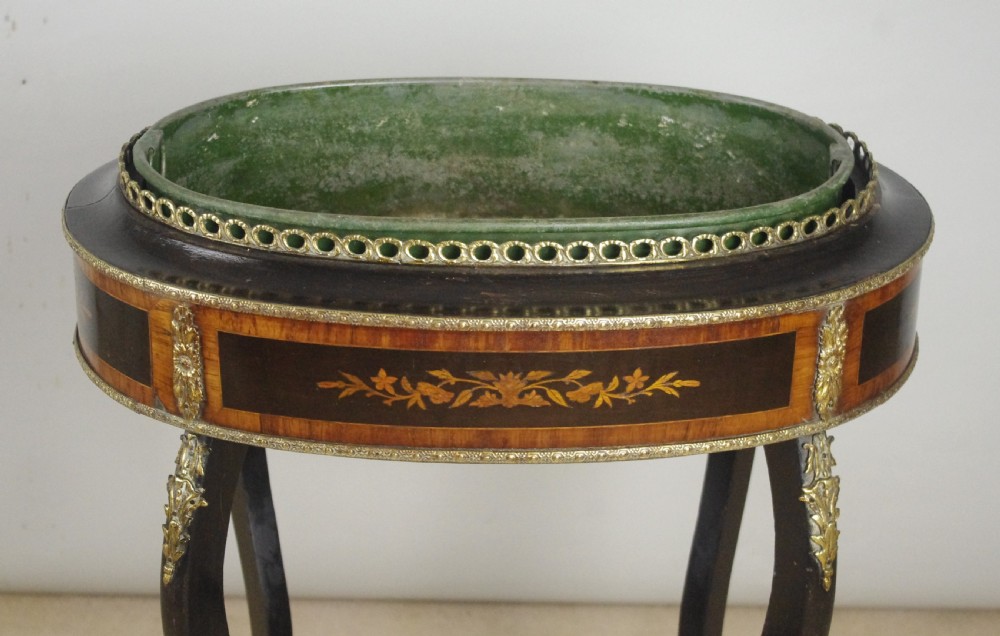 A 19th-century French oval ebonised jardiniere table featuring floral marquetry frieze, gilt-bronze mounts, cabriole legs, and a green metal liner with a pierced brass gallery. View VI