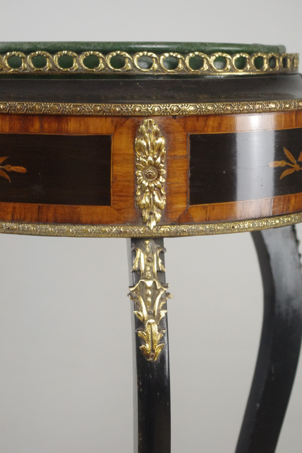 A 19th-century French oval ebonised jardiniere table featuring floral marquetry frieze, gilt-bronze mounts, cabriole legs, and a green metal liner with a pierced brass gallery. View VIII