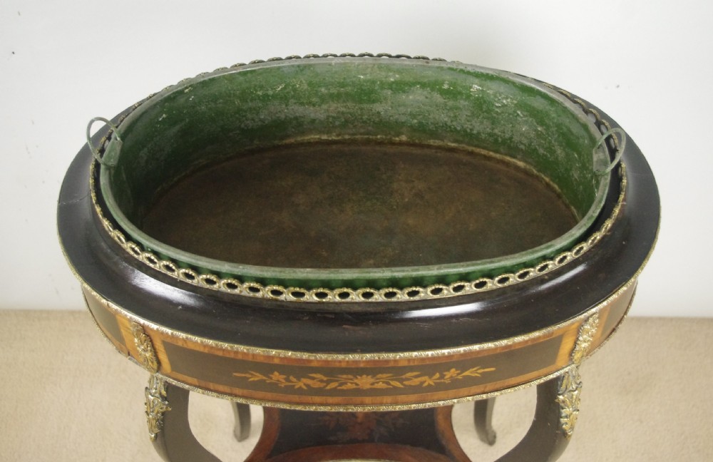 A 19th-century French oval ebonised jardiniere table featuring floral marquetry frieze, gilt-bronze mounts, cabriole legs, and a green metal liner with a pierced brass gallery. View X