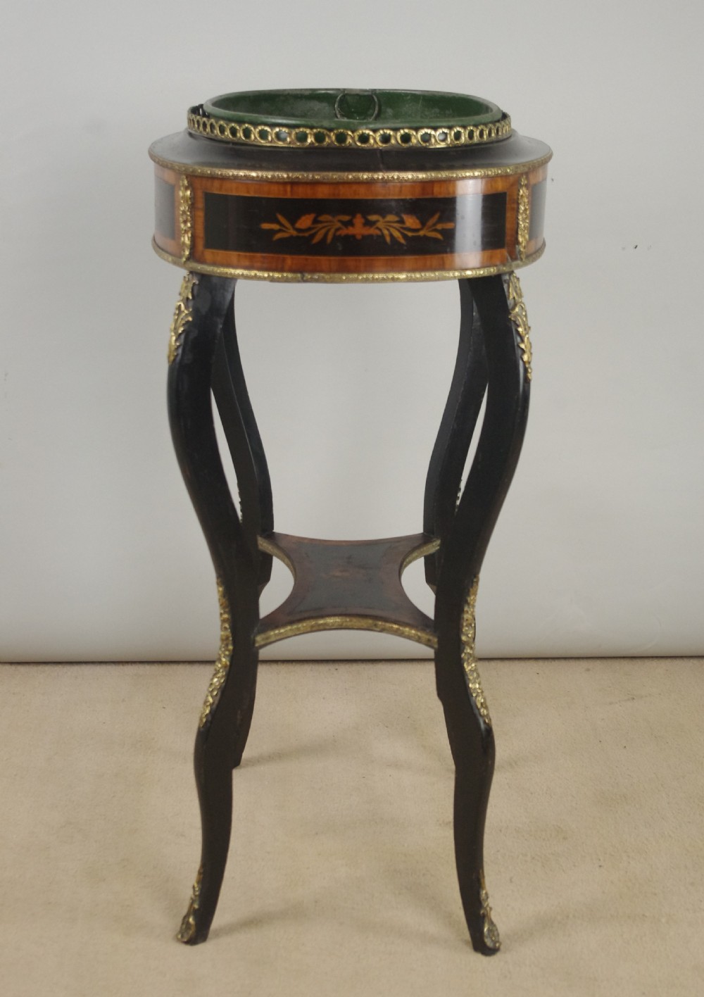A 19th-century French oval ebonised jardiniere table featuring floral marquetry frieze, gilt-bronze mounts, cabriole legs, and a green metal liner with a pierced brass gallery. View XII