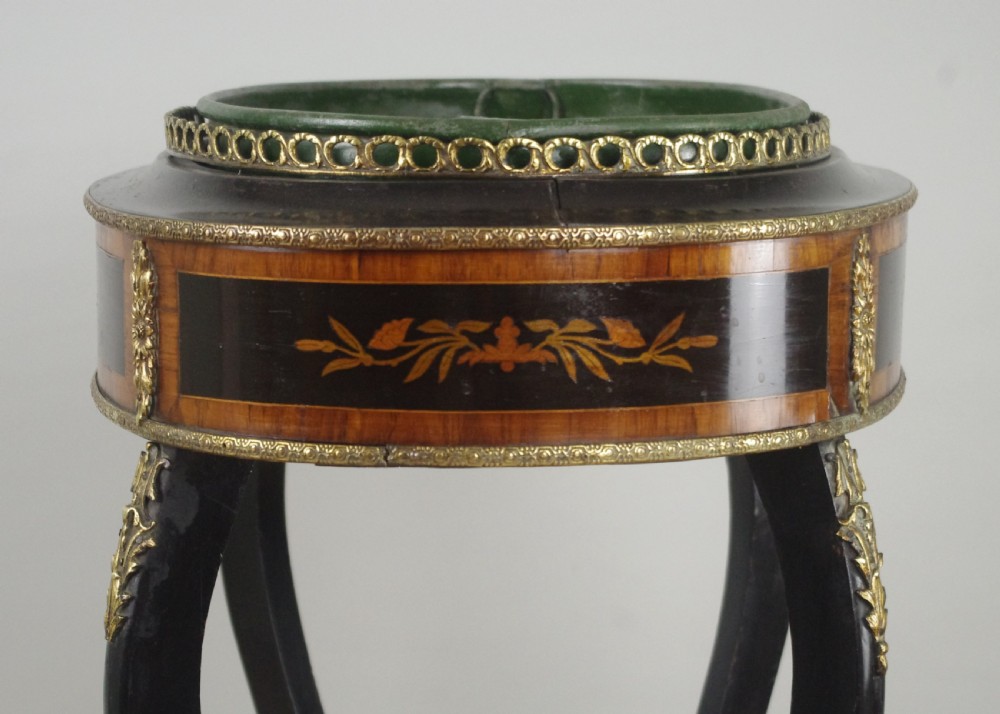 A 19th-century French oval ebonised jardiniere table featuring floral marquetry frieze, gilt-bronze mounts, cabriole legs, and a green metal liner with a pierced brass gallery. View XIII