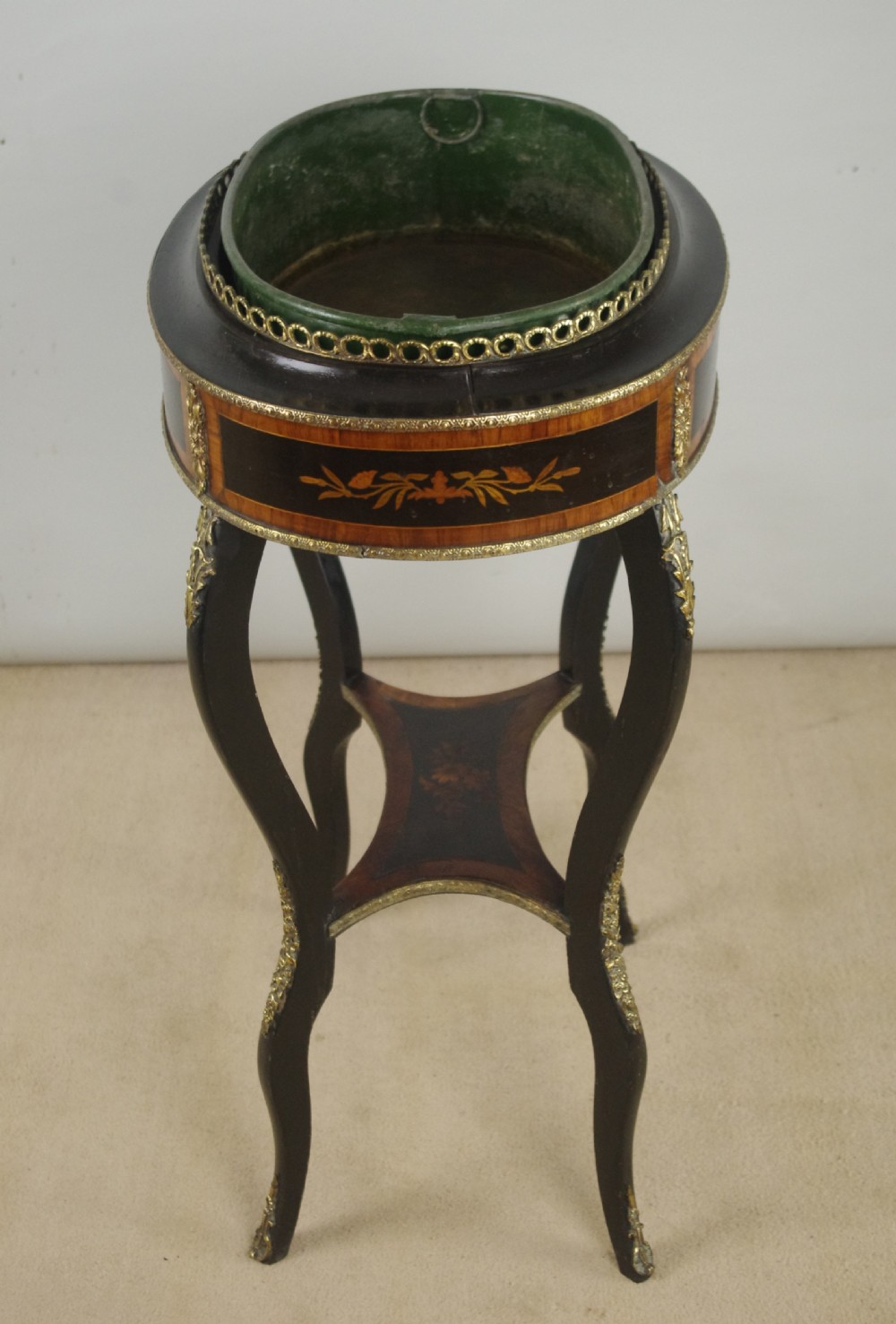 A 19th-century French oval ebonised jardiniere table featuring floral marquetry frieze, gilt-bronze mounts, cabriole legs, and a green metal liner with a pierced brass gallery. View XIV