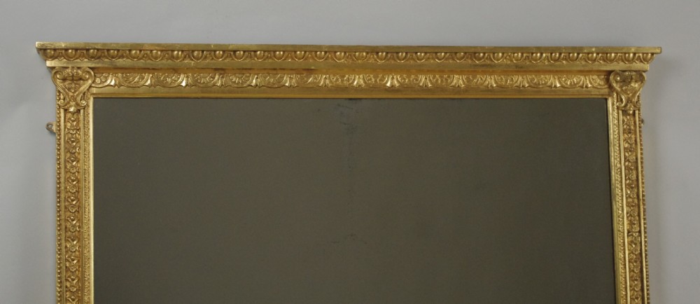 A wide rectangular Victorian overmantel mirror featuring a gilded frame with egg-and-dart moulding and detailed side pilasters. View VI