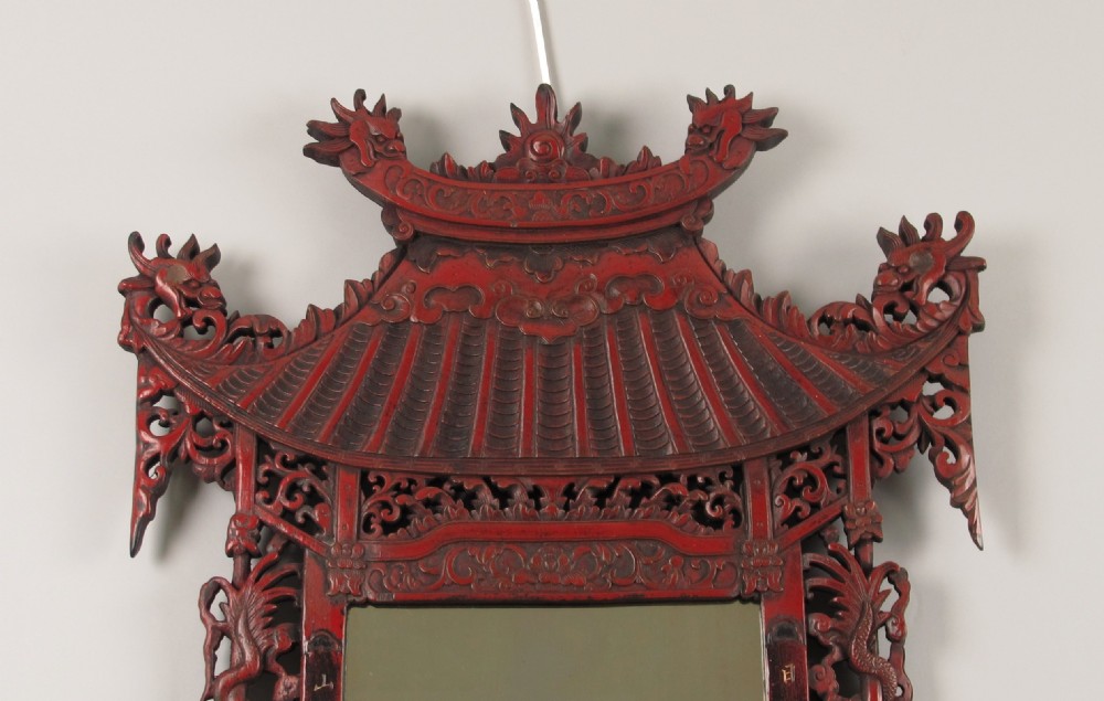 A 19th-century Chinese red lacquer wall mirror featuring a carved pagoda top, dragon side columns, and calligraphic text. View II