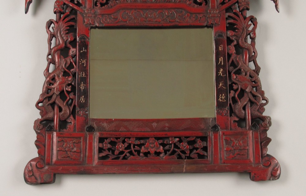 A 19th-century Chinese red lacquer wall mirror featuring a carved pagoda top, dragon side columns, and calligraphic text. View III