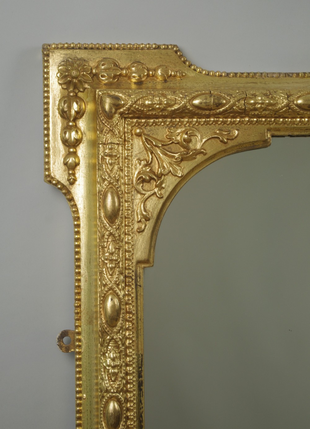 A Victorian giltwood overmantel mirror with an arched frame, central shell crest, and beaded moulding against a neutral backdrop. View III