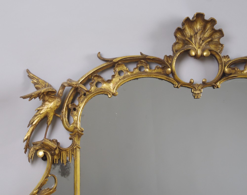 A 19th-century Chinese Chippendale style giltwood overmantel mirror featuring pierced rococo scrollwork, acanthus cresting, and carved exotic birds flanking the central glass. View V