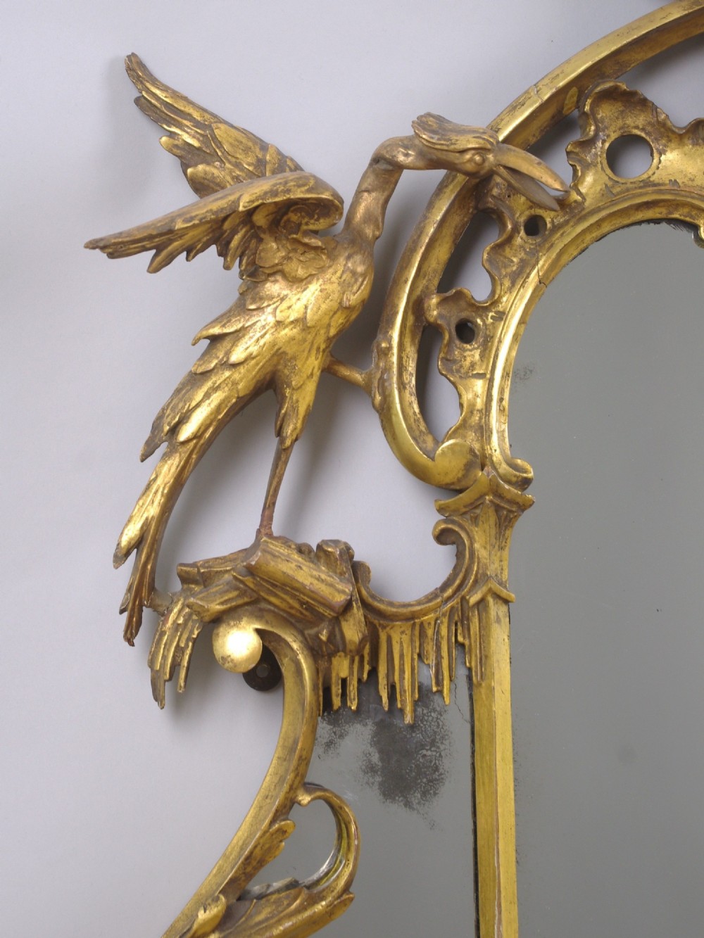 A 19th-century Chinese Chippendale style giltwood overmantel mirror featuring pierced rococo scrollwork, acanthus cresting, and carved exotic birds flanking the central glass. View VII