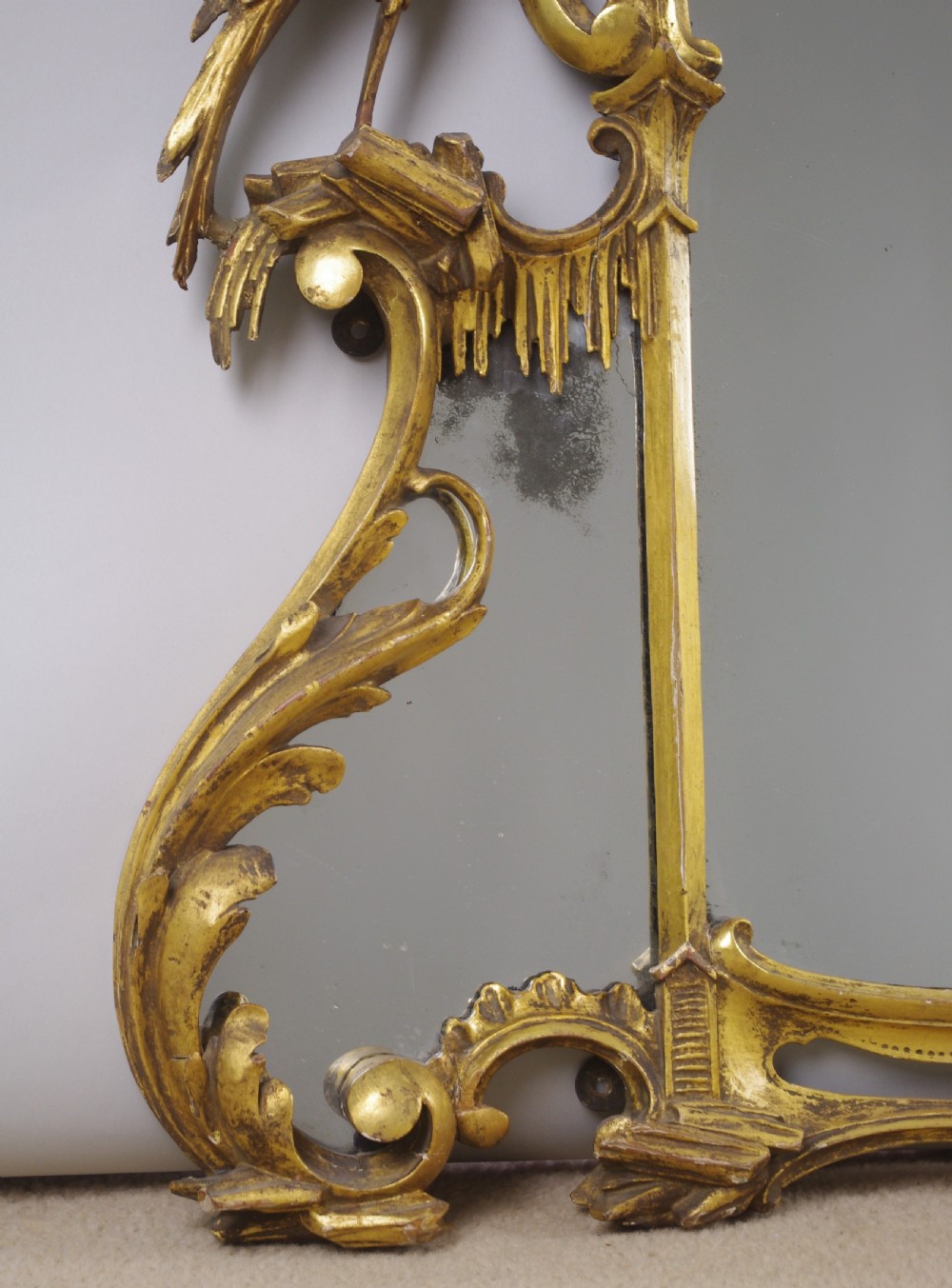 A 19th-century Chinese Chippendale style giltwood overmantel mirror featuring pierced rococo scrollwork, acanthus cresting, and carved exotic birds flanking the central glass. View IX