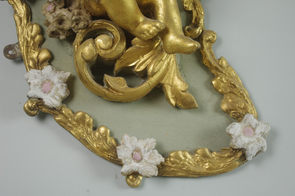 A pair of 19th-century French gilt wall lights featuring sculpted putti figures seated within asymmetrical gilded Rococo floral frames with frosted glass flower shades. View VIII