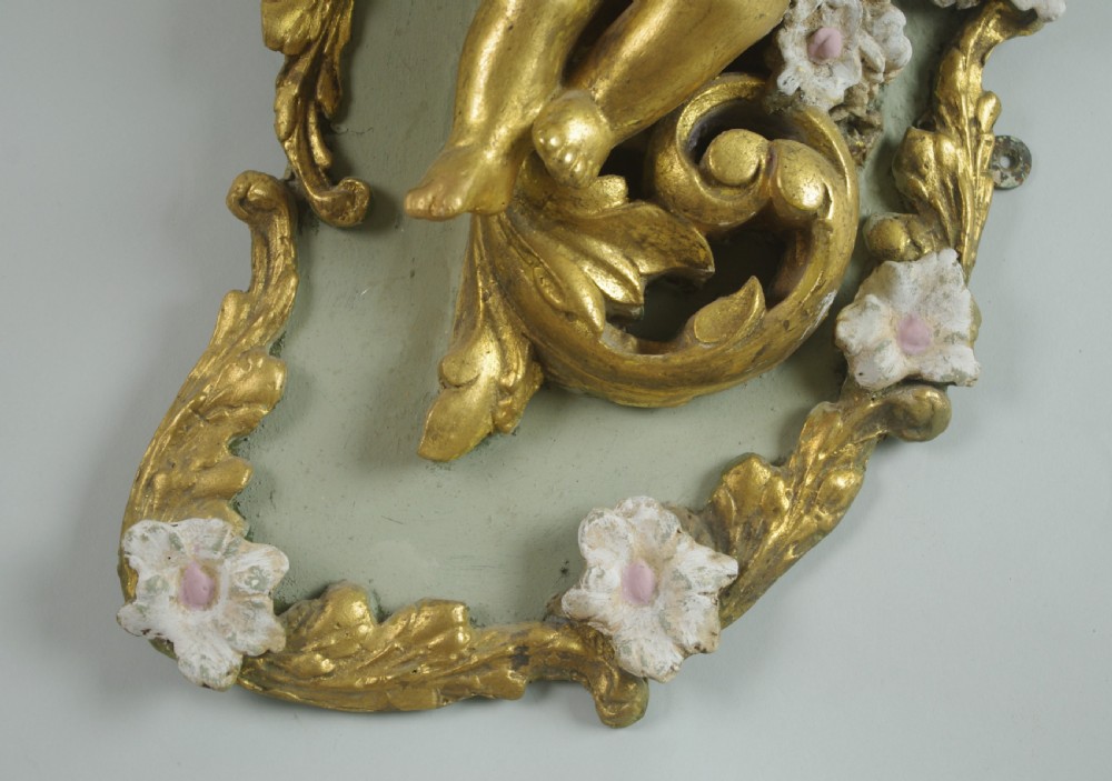 A pair of 19th-century French gilt wall lights featuring sculpted putti figures seated within asymmetrical gilded Rococo floral frames with frosted glass flower shades. View IX