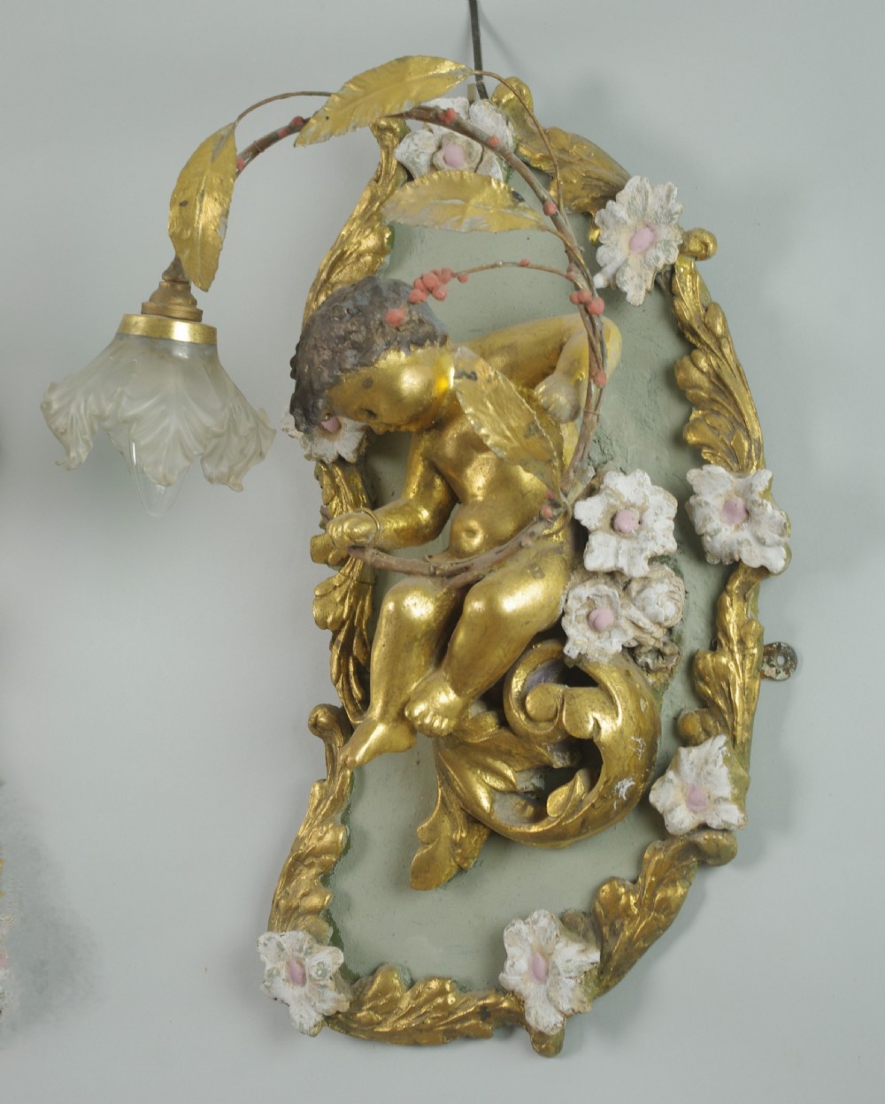 A pair of 19th-century French gilt wall lights featuring sculpted putti figures seated within asymmetrical gilded Rococo floral frames with frosted glass flower shades. View XI